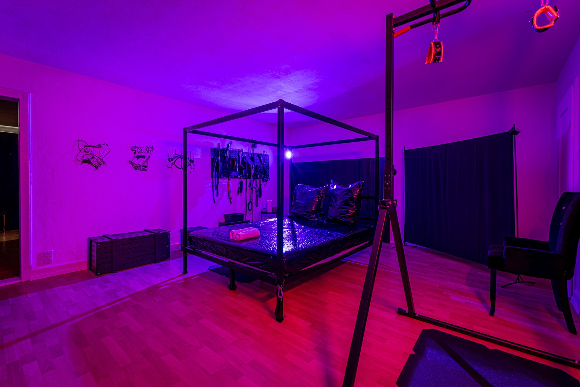 BDSM-Zimmer im Studio34 Lenzburg mit Himmelbett-Gestell in violettem Licht